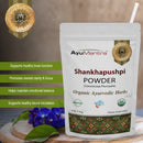AyuMantra Shankhapushpi Powder benefits, packaged with product details on a wooden surface.