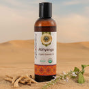 Bottle of Ayumantra Abhyanga Organic Ayurvedic Oil on sand with desert background