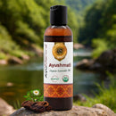 Ayushmati Organic Ayurvedic Oil bottle with natural elements on a blurred nature background