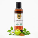 Bottle of Brahmi Amla organic ayurvedic oil with ingredients on a white background