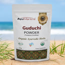 AyuMantra Guduchi Powder package on a beach with ocean in the background