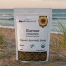 AyuMantra Gurmar Powder packaging on a beach