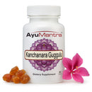 AyuMantra Kanchanara Guggulu dietary supplement bottle with flowers on a white background