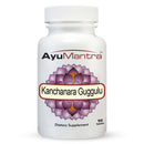 A bottle of AyuMantra Kanchanara Guggulu dietary supplement with 90 tablets, featuring a purple and white label.