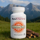 AyuMantra Licorice Root supplement bottle with licorice roots on grass with mountains in the background