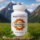AyuMantra Moringa dietary supplement bottle with a mountainous background