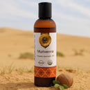 Bottle of Murivenna organic ayurvedic oil with a coconut on sand dunes