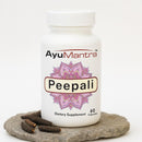 AyuMantra Peepali dietary supplement bottle on a stone surface with a white background