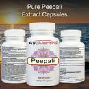 Three white bottles of AyuMantra Pure Peepali Extract Capsules shown against a sunset over ocean background. The center bottle is front-facing with a white cap, white label, and pink mandala-style Peepali graphic, while the side bottles show the back labels.