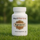 AyuMantra Agnacid dietary supplement bottle on grass with a blurred green background.