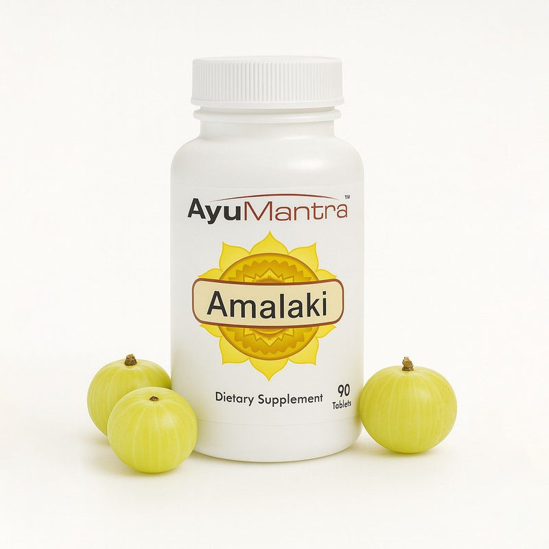 AyuMantra Amalaki tablets bottle with fresh amla fruits arranged on a clean white background