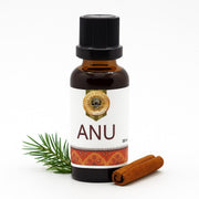 Bottle of ANU oil with a cinnamon stick and pine needle on a white background
