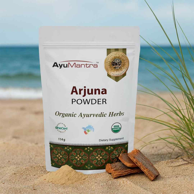 AyuMantra Arjuna Powder packaging on a beach with ocean view