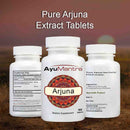 Three bottles of AyuMantra Arjuna dietary supplements on a blurred natural background.