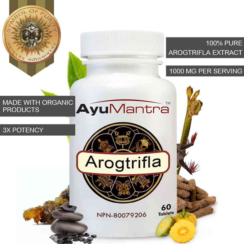 AyuMantra Arogtrifla supplement bottle with herbal elements on a white background.