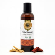Bottle of baby massage organic ayurvedic oil with a decorative label on a white background