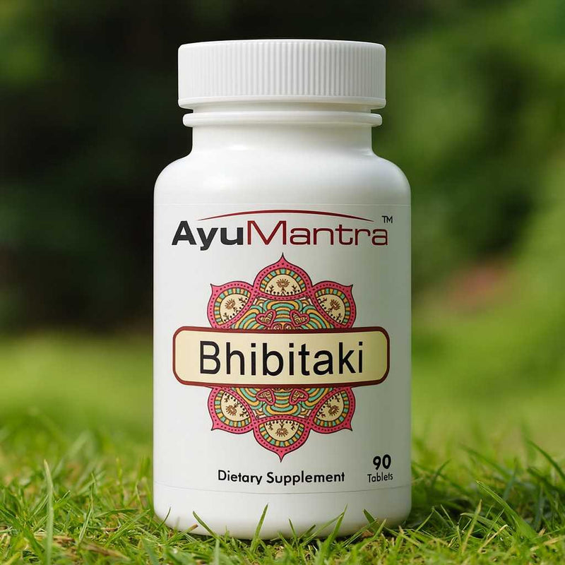 Ayumantra Bhibitaki tablets bottle standing on green grass with a soft natural background