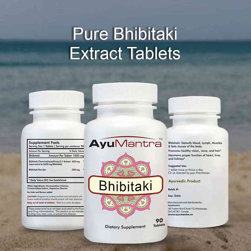 AyuMantra Bhibitaki supplement bottles on a beach with ocean in the background.