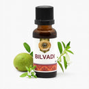 Bottle of Bilvadi oil with a green fruit and leaves on a white background