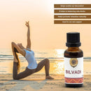 Bottle of BILVADI oil with a woman practicing yoga on a beach at sunset.