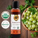 Brahmi Amla organic ayurvedic oil bottle with USDA Organic and OneCert Organic logos, surrounded by gooseberries on a wooden background.
