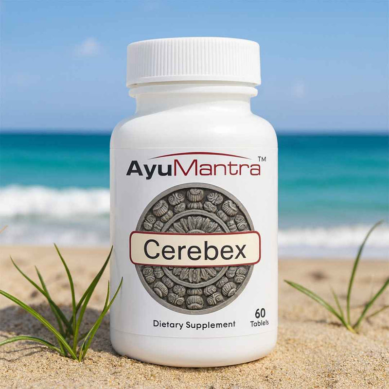 AyuMantra Cerebex dietary supplement bottle on a sandy beach with ocean in the background.