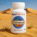 AyuMantra Chitrakadi dietary supplement bottle in a desert setting.
