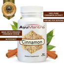 AyuMantra Cinnamon dietary supplement bottle with cinnamon sticks and leaves on a white background