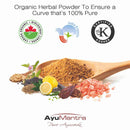 Organic herbal powder with a wooden spoon, lemon, and various herbs on a white background, featuring AyuMantra branding.