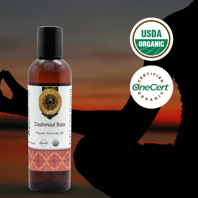 Bottle of Dashmool Bala organic ayurvedic oil with USDA Organic and OneCert logos on a blurred background.