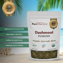 AyuMantra Dashmool Powder packaging with product details and branding on a scenic background.