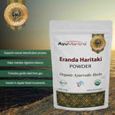 AyuMantra Eranda Haritaki Powder packaging with product details on a textured surface.