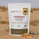 AyuMantra Gokshura Powder packaging on a desert background