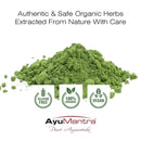 Green herb powder with AyuMantra branding and certification logos on a white background