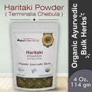 Packaging of AyuMantra Haritaki Powder with branding and product details on a light gray background.