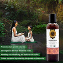 Bottle of Japakusumadi organic Ayurvedic oil with a woman and child in a natural setting.
