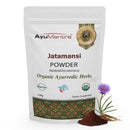 AyuMantra Jatamansi Powder packaging with herbs and flower on a white background
