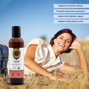 Woman lying on grass with a bottle of Jatyadi Organic Ayurvedic Oil against a blue sky.