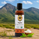 Bottle of Kapha organic ayurvedic oil with a mountainous background