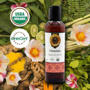 Bottle of Ksheerbala Organic Ayurvedic Oil surrounded by natural elements and certification logos.