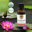 Bottle of Kumkumadi Organic Ayurvedic Oil with USDA Organic and OneCert logos, surrounded by lotus flowers.