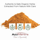 Pile of orange powder with AyuMantra branding and certification logos on a white background