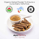 Organic herbal powder with dried roots on a white plate, featuring certification logos and AyuMantra branding.