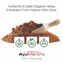 Pile of organic herbs with a wooden scoop and AyuMantra branding on a white background