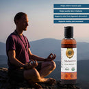 Man meditating with a bottle of Murivenna Organic Aюрvéedic Oil against a mountainous background