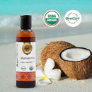 Bottle of Murivenna Organic Ayurvedic Oil with coconuts and a flower on a beach background