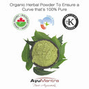 Green herbal powder in a bowl surrounded by leaves with certification logos above on a white background.