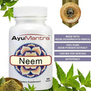 AyuMantra Neem dietary supplement bottle with neem leaves and powder on a white background