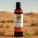 Bottle of Nirgundi organic ayurvedic oil in a desert setting