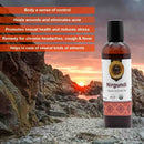 Nirgundi Organic Ayurvedic Oil bottle with sunset and rocky landscape in the background
